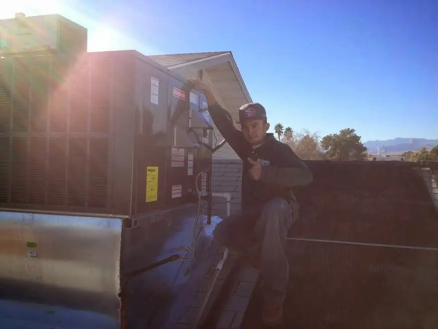 HVAC technician performing HVAC Inspection on a rooftop unit in Loxley